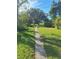 Landscaped path leading through lush greenery towards a tree at 3536 Countrybrook Ln # 13, Palm Harbor, FL 34684