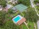 Aerial view highlighting community tennis courts and pool surrounded by lush trees and residential homes at 3673 Fremantle Dr, Palm Harbor, FL 34684