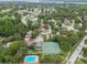 Aerial view of the neighborhood featuring mature trees, a pool, and tennis courts at 3673 Fremantle Dr, Palm Harbor, FL 34684