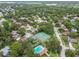 Expansive aerial view of the community featuring tennis courts, a pool, and tree-lined streets at 3673 Fremantle Dr, Palm Harbor, FL 34684