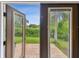 View of the backyard from inside the home, featuring a garden at 3673 Fremantle Dr, Palm Harbor, FL 34684