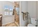 Bathroom featuring a glass shower enclosure, a window with plantation shutters, and a toilet at 3673 Fremantle Dr, Palm Harbor, FL 34684