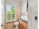 Elegant bathroom with a modern sink, wood vanity, and large shuttered window at 3673 Fremantle Dr, Palm Harbor, FL 34684