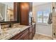 Bathroom with granite countertops, wood cabinets, and tiled floors at 3673 Fremantle Dr, Palm Harbor, FL 34684