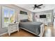 Comfortable bedroom with white dressers, a ceiling fan, and sunlit windows at 3673 Fremantle Dr, Palm Harbor, FL 34684