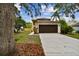 Two-story home with a well-manicured lawn, brown two-car garage and mature trees in a desirable community at 3673 Fremantle Dr, Palm Harbor, FL 34684