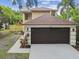 Attractive home exterior showcasing a large two-car garage, a well-maintained lawn, and mature trees at 3673 Fremantle Dr, Palm Harbor, FL 34684