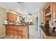 Open kitchen with wood cabinets and countertop seating, adjacent to a built-in desk at 3673 Fremantle Dr, Palm Harbor, FL 34684