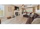Spacious living room with wood-look flooring, a fireplace, and a large window for natural light at 3673 Fremantle Dr, Palm Harbor, FL 34684