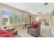 Sunlit living room boasts wood-look flooring, large windows, and stylish decor and furniture at 3673 Fremantle Dr, Palm Harbor, FL 34684