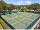 Aerial view of multiple tennis courts surrounded by lush landscaping, offering recreational opportunities at 3673 Fremantle Dr, Palm Harbor, FL 34684