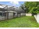 Landscaped backyard with pool enclosure, offering a private outdoor oasis perfect for relaxation and entertainment at 37331 Hickory Hill Ln, Dade City, FL 33525