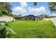 The backyard features a lush lawn, storage shed, and screened in pool for leisure and storage at 37331 Hickory Hill Ln, Dade City, FL 33525