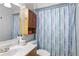 Full bathroom featuring tiled walls, vanity with sink, toilet, and shower with blue striped curtain at 37331 Hickory Hill Ln, Dade City, FL 33525