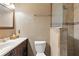 Well-lit bathroom with a vanity, toilet, and a shower with partial glass enclosure at 37331 Hickory Hill Ln, Dade City, FL 33525
