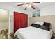 Bedroom featuring a large closet with a red curtain, painting, and ceiling fan at 37331 Hickory Hill Ln, Dade City, FL 33525