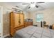 Bedroom with neutral wallpaper, ceiling fan, a wardrobe and wooden dresser at 37331 Hickory Hill Ln, Dade City, FL 33525