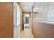 Hallway with tile flooring leads to another room showcasing tile shower through a glass partition at 37331 Hickory Hill Ln, Dade City, FL 33525