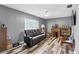 Comfortable living room with wood-look flooring, a ceiling fan, and a reclining sofa at 37331 Hickory Hill Ln, Dade City, FL 33525