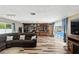 Open living room featuring wood-look floors, a large bookshelf, and sliding glass doors to the pool at 37331 Hickory Hill Ln, Dade City, FL 33525