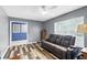 Relaxing living room with wood-look flooring, a ceiling fan, and a comfortable reclining sofa at 37331 Hickory Hill Ln, Dade City, FL 33525