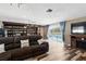 Living room with pool views, wood-look floors, a sectional couch, and a built-in bookshelf bar at 37331 Hickory Hill Ln, Dade City, FL 33525