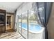 Indoor view through glass doors of a sparkling pool and screened-in patio at 37331 Hickory Hill Ln, Dade City, FL 33525