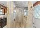 A luxurious tile shower has glass doors and trim, a rainfall shower head, and built-in niches at 37331 Hickory Hill Ln, Dade City, FL 33525