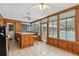 Sunroom featuring wood paneling, tile floors, bar and ample natural light at 37331 Hickory Hill Ln, Dade City, FL 33525