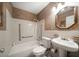 Cozy bathroom featuring a bathtub, toilet, pedestal sink, and textured wallpaper at 4650 87Th N Ter, Pinellas Park, FL 33782
