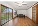 Bright dining area featuring wood floors, a ceiling fan, and sliding glass doors to the backyard at 4650 87Th N Ter, Pinellas Park, FL 33782
