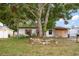 Charming single-story home featuring wood shutters and a stone-ringed tree in a lush front yard at 4650 87Th N Ter, Pinellas Park, FL 33782
