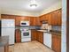 Functional kitchen with tile floors, wood cabinets, and white appliances, maximizing space and efficiency at 4650 87Th N Ter, Pinellas Park, FL 33782