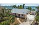 Charming waterfront home with lush landscaping, a concrete driveway, and a detached garage at 4749 Baywood Point S Dr, Gulfport, FL 33711