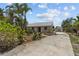 Well-maintained single-story home with lush landscaping, a long driveway and a detached building at 4749 Baywood Point S Dr, Gulfport, FL 33711