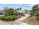 Charming exterior featuring lush, mature landscaping, offering curb appeal and privacy to the home at 4749 Baywood Point S Dr, Gulfport, FL 33711