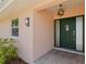 A dark green front door with sidelights is illuminated by stylish sconces and a starburst pendant light at 4749 Baywood Point S Dr, Gulfport, FL 33711