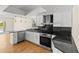 Modern kitchen boasts stainless steel appliances, white cabinets, and granite countertops at 4749 Baywood Point S Dr, Gulfport, FL 33711