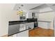 Stylish kitchen features white cabinets, black countertops, stainless steel appliances, and unique lighting at 4749 Baywood Point S Dr, Gulfport, FL 33711