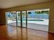 Bright living room featuring sliding glass doors opening to a waterfront pool and bay views at 4749 Baywood Point S Dr, Gulfport, FL 33711