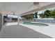 Covered patio with ceiling fans overlooking a waterfront pool with a white fence and picturesque views at 4749 Baywood Point S Dr, Gulfport, FL 33711