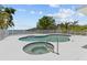 Sparkling in-ground pool and hot tub with a white fence and waterfront views at 4749 Baywood Point S Dr, Gulfport, FL 33711