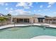 A backyard swimming pool surrounded by a white fence and a covered patio for relaxation at 4749 Baywood Point S Dr, Gulfport, FL 33711