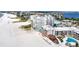 Stunning aerial view showcasing the beachfront condo, pristine beach, and sparkling pools at 4950 Gulf Blvd # 404, St Pete Beach, FL 33706