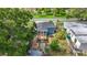 Aerial view of a cozy home with a well-manicured yard, deck, brick path, and lush greenery at 5005 Tangerine S Ave, Gulfport, FL 33707