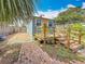 Charming backyard with a blue shed, wooden deck, brick pathway, and garden landscaping at 5005 Tangerine S Ave, Gulfport, FL 33707