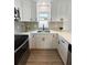 This kitchen features white cabinets, stainless steel appliances, and a large sink under a window at 5151 7Th N Ave, St Petersburg, FL 33710