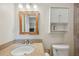 Bathroom featuring a granite countertop, white vanity, and custom mirror with wooden frame at 5451 Antigua Dr, Zephyrhills, FL 33541