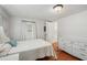 Simple bedroom featuring a bright, white aesthetic and hardwood floors, with adjacent bathroom at 5451 Antigua Dr, Zephyrhills, FL 33541
