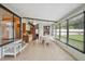 Sunroom dining area with ceiling fan, large windows, tiled floor, and adjacent kitchen at 5451 Antigua Dr, Zephyrhills, FL 33541